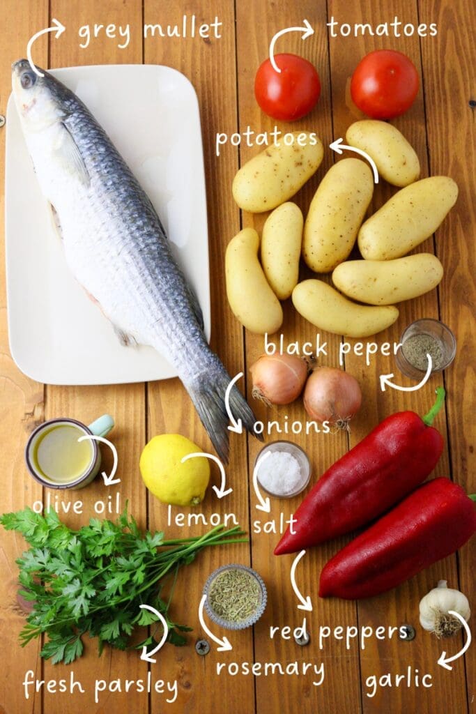 gathering the ingredients for the recipe: fresh grey mullet, potatoes, tomatoes, peppers, onions, garlic, parsley, olive oil, lemon, salt, black pepper and rosemary.